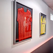 Vom Flur geht es rechts und links in die Behandlungsräume. An der Wand hängen Trikots der Ruhrpottvereine wie dem FC Schalke, VFL Bochum, Rot-Weiss Essen und Rot-Weiß Oberhausen. Flur im Erdgeschoss